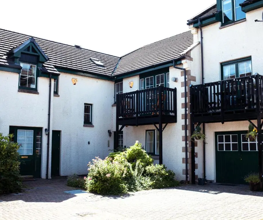 a house with a green door and a balcony at The River Nest in Dalneigh