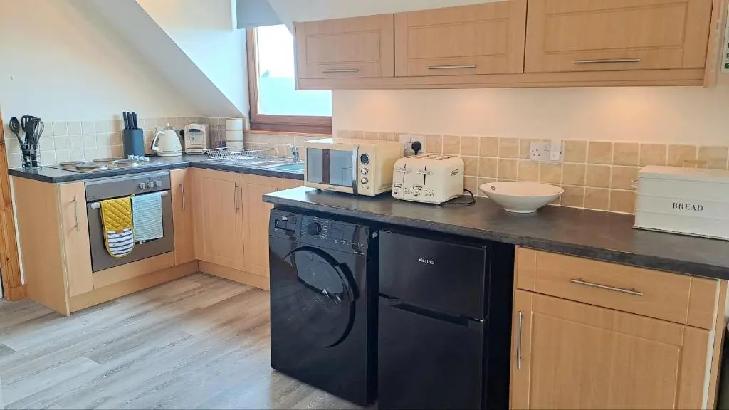 a kitchen with a black dish washer and dryer at Balormie View in Lossiemouth