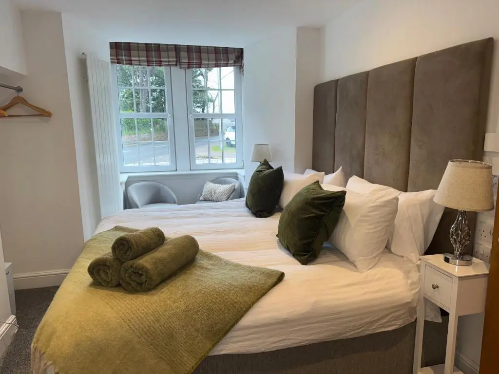 a bedroom with a large bed with pillows on it at Altonhill Cottage - room only in Nairn