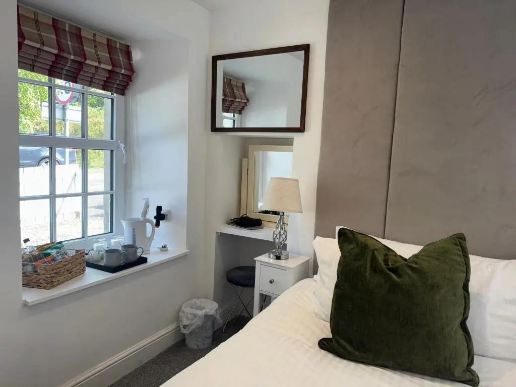 a bedroom with a bed with a mirror and a window at Altonhill Cottage - room only in Nairn