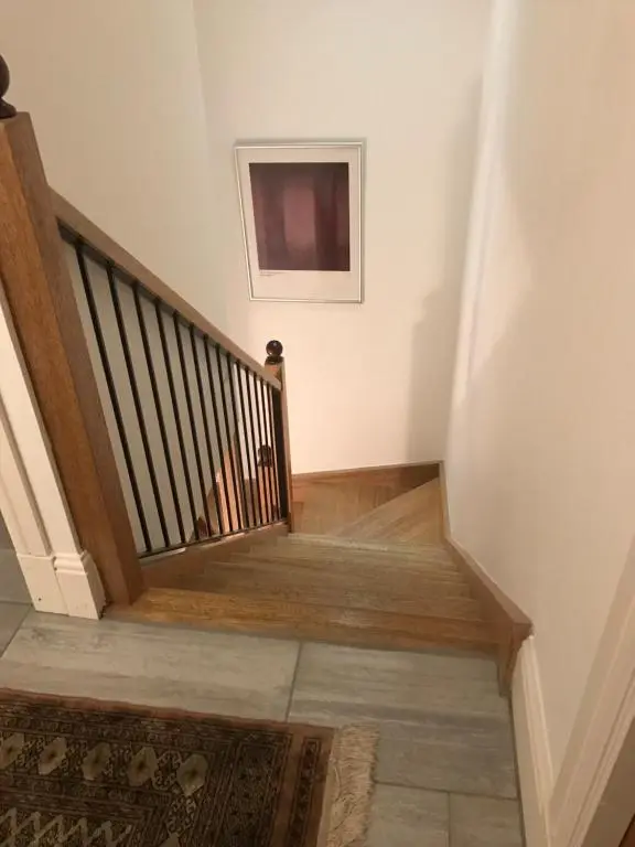 a hallway with a staircase with a television on the wall at Scardroy Homes Inverness - Central 2 Bedroom with Parking WiFi Smart TVs Sleeps up to 6 in Inverness