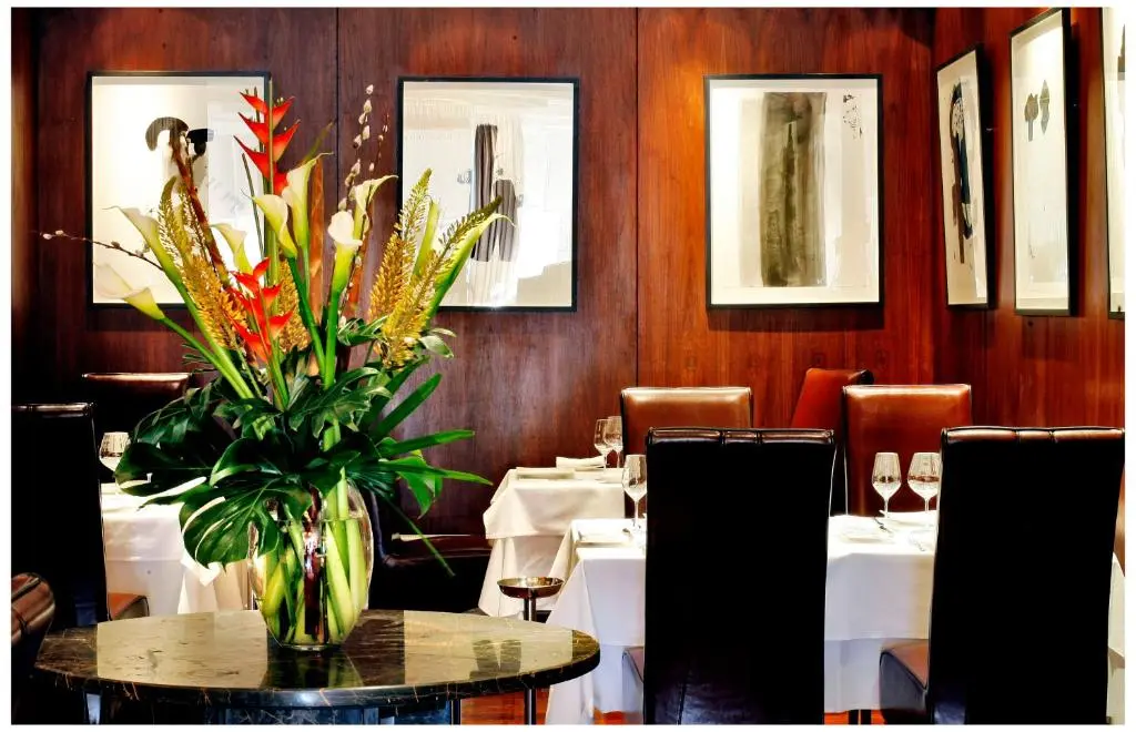 a dining room with a table with a vase of flowers at The Glenmoriston Townhouse Hotel in Inverness