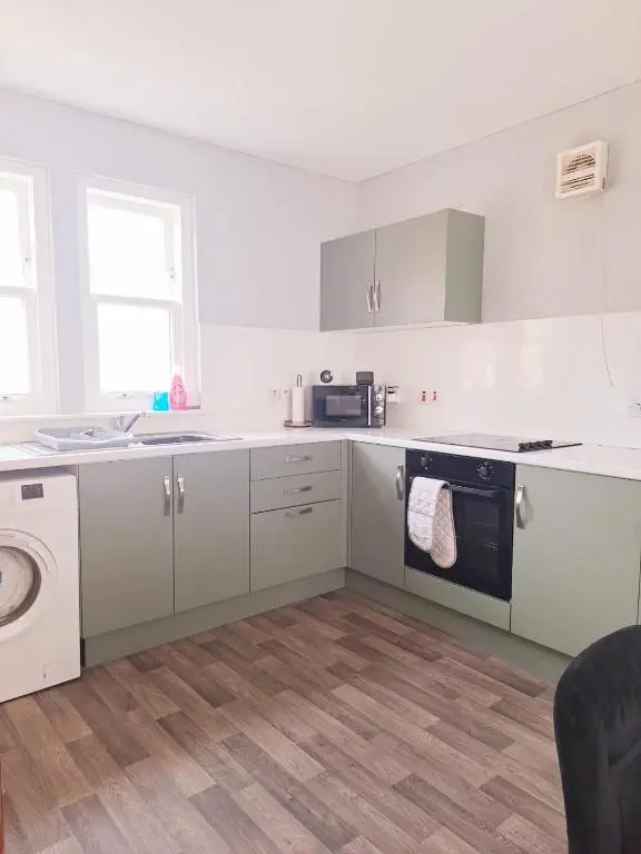 a white kitchen with a sink and a dishwasher at 3 Bedroom Townhouse on NC500, Wick, Highland in Wick