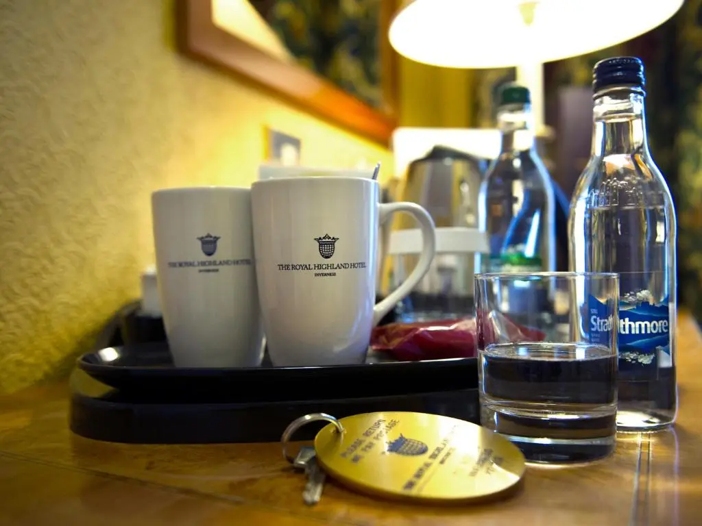 a tray with two cups and a glass of water at The Royal Highland Hotel in Inverness