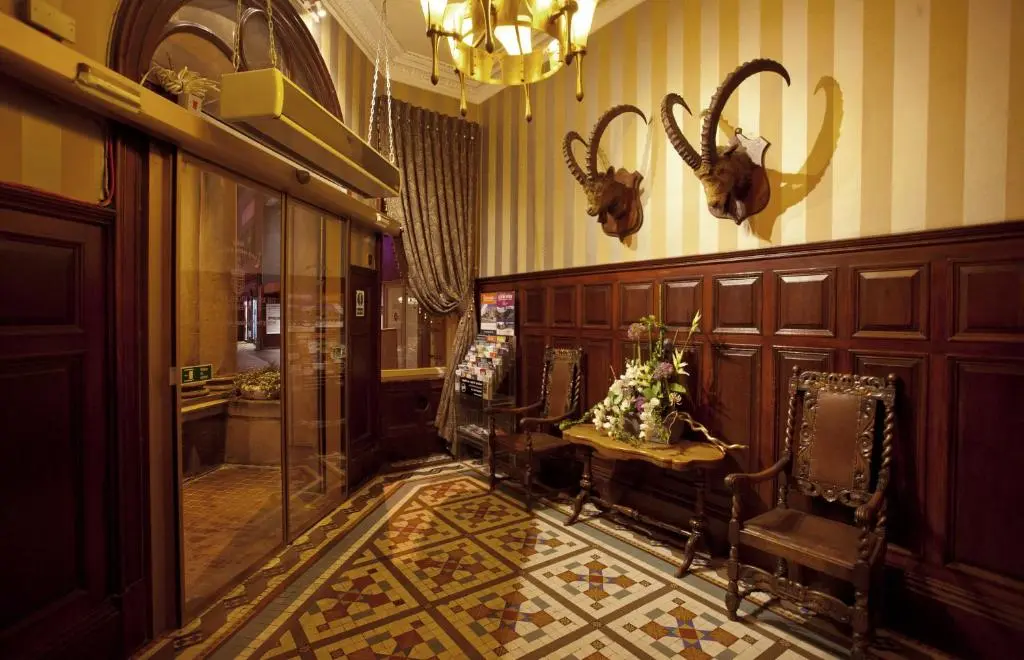 a hallway with chairs and antlers on the wall at The Royal Highland Hotel in Inverness