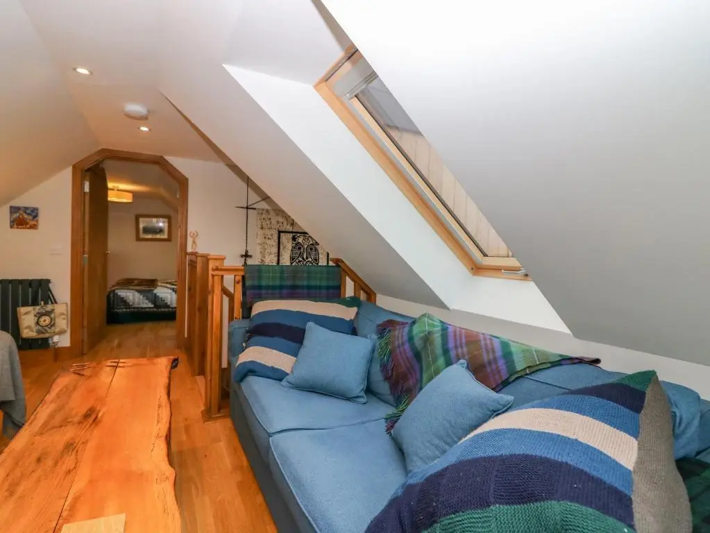 a living room with a blue couch with blue pillows at Otakaro in Tomintoul