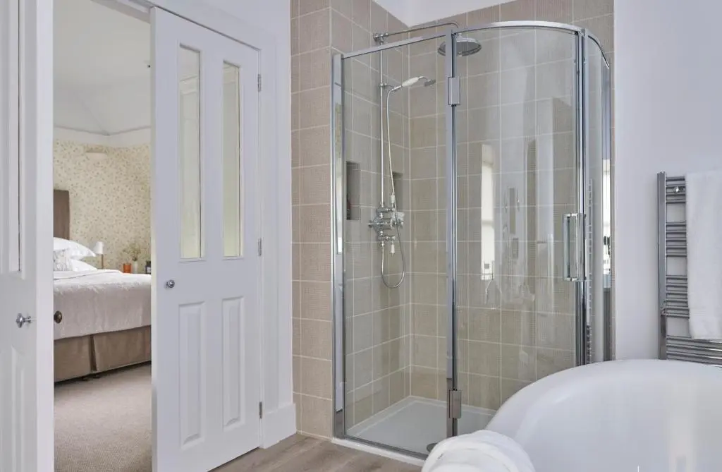 a bathroom with a shower with a glass door at Achnahatnich House in Aviemore