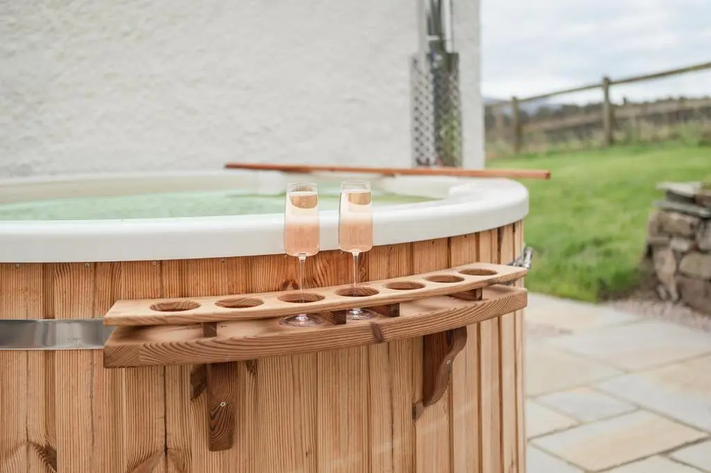 a jacuzzi tub with sandals on top of it at Gleann Cottage - Seasgair Lodges in Kincraig