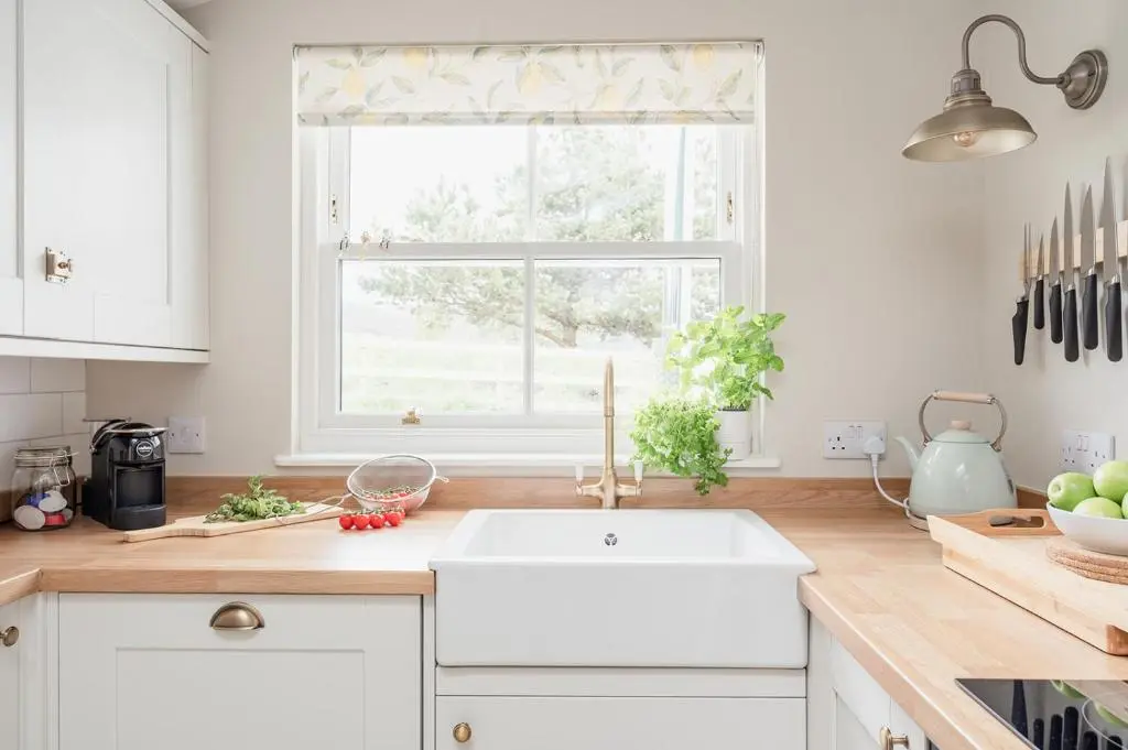 a kitchen with a white sink and a window at Beinn Cottage - Seasgair Lodges in Kincraig