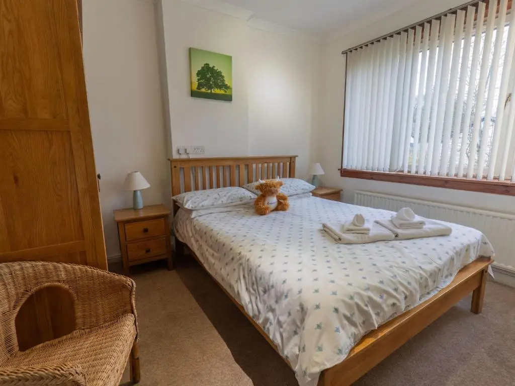 a bedroom with a teddy bear sitting on a bed at Holiday Home Beech by Interhome in Inverness