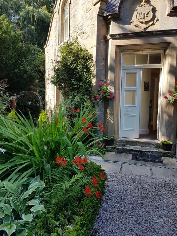a front door of a house with flowers and plants at Dalvey East Lodge in Forres