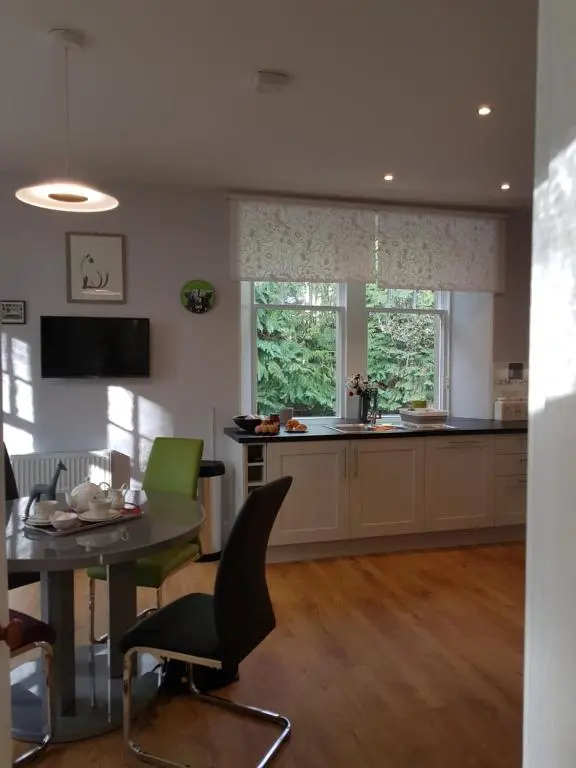 a kitchen with a table and chairs and a window at Dalvey East Lodge in Forres