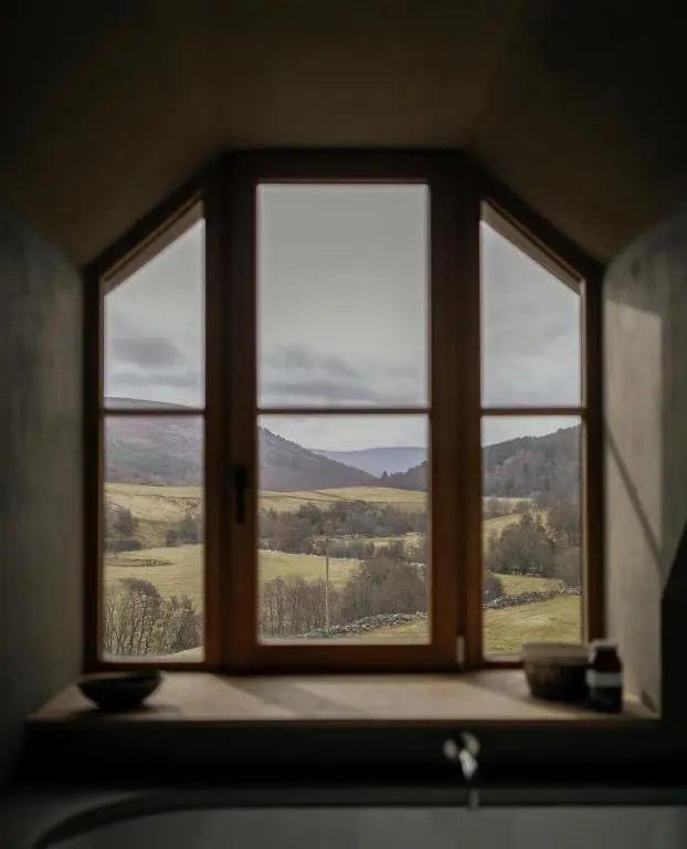 a window in a room with a view of a field at Inverenzie Cottage, Rooms with a view! in Coilacriech