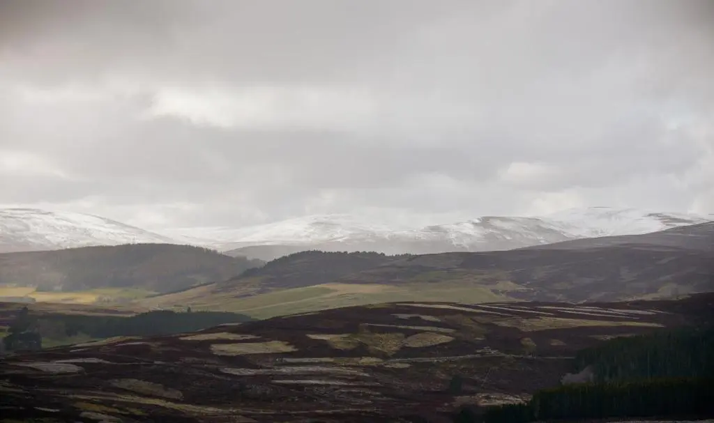 a view of a mountain range with snow covered mountains at Inverenzie Cottage, Rooms with a view! in Coilacriech