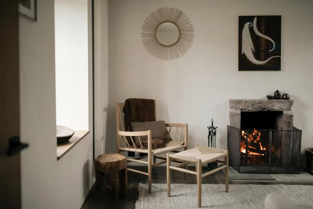 a living room with a chair and a fireplace at Inverenzie Cottage, Rooms with a view! in Coilacriech