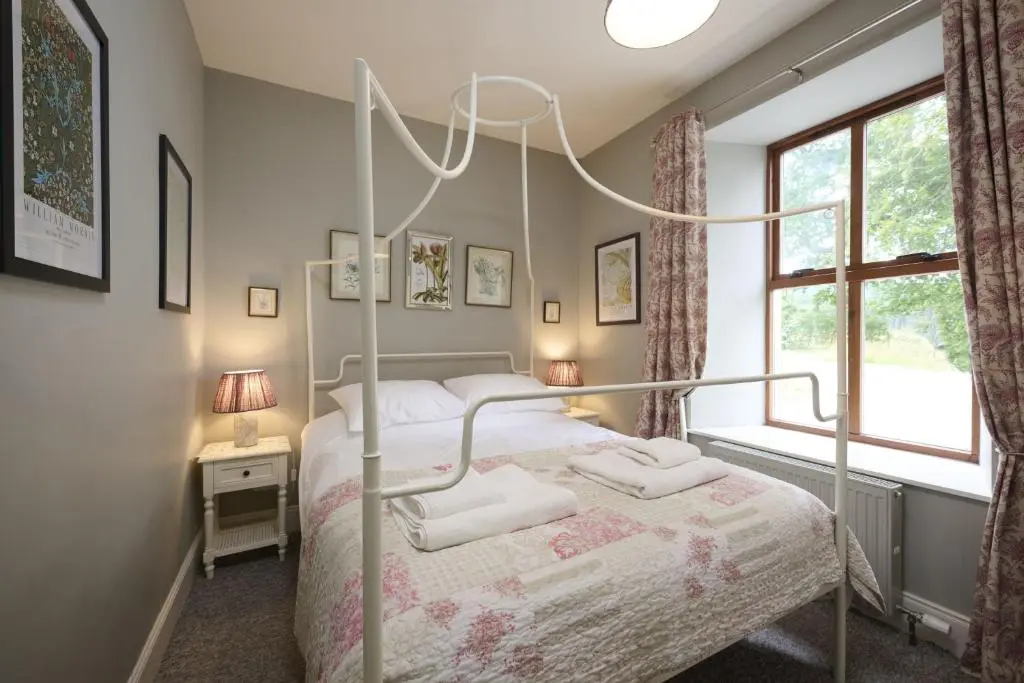 a bedroom with a canopy bed with towels on it at Dunaincroy Farmhouse in Inverness