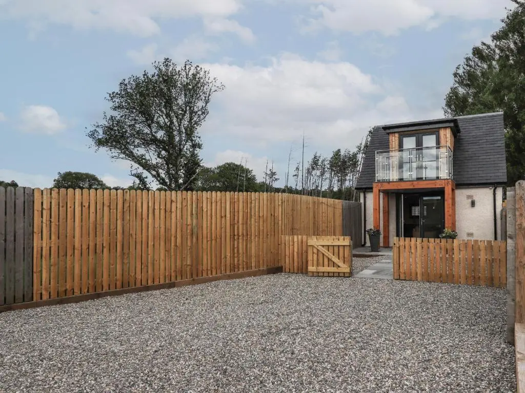 a wooden fence in front of a house at Wee Smithy in Munlochy