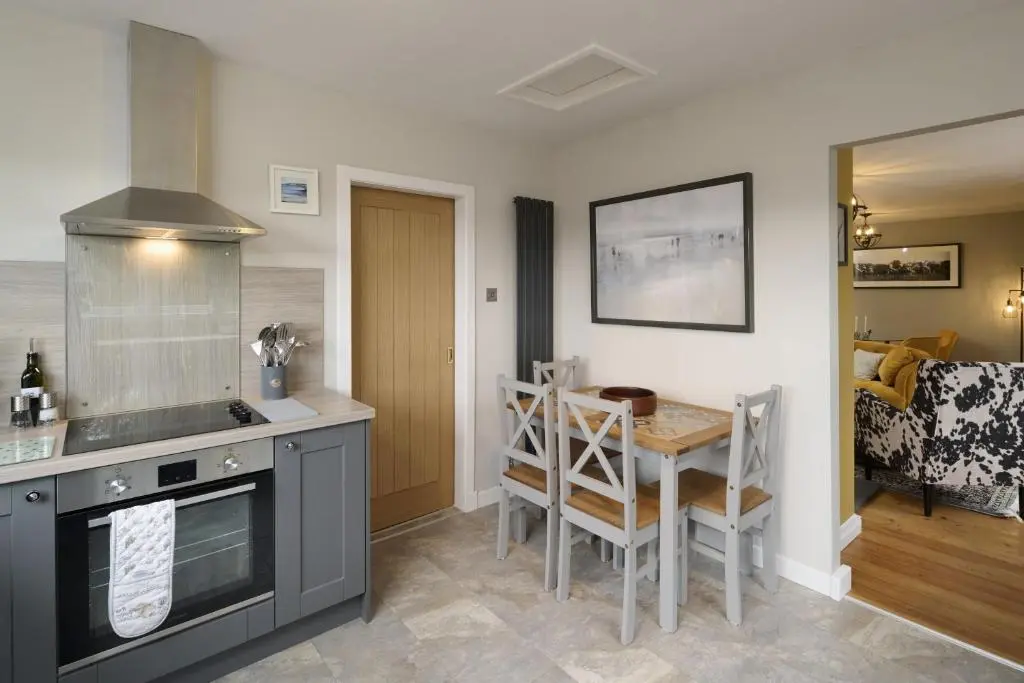 a kitchen with a table and a dining room at Glen View in Inverness