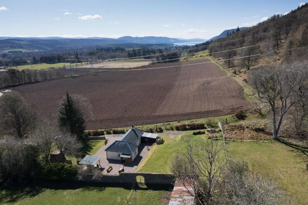 an aerial view of a farm house and a field at Glen View in Inverness