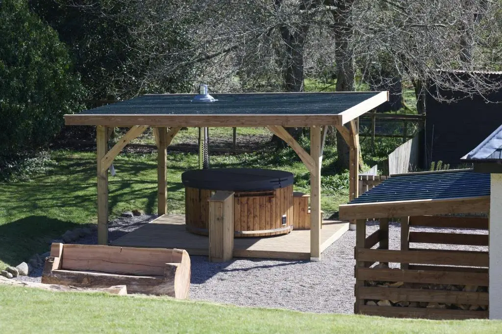 a wooden gazebo with a swing and a table at Glen View in Inverness