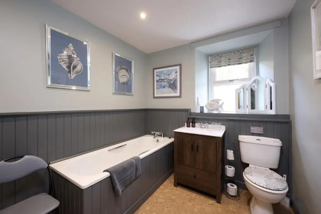a bathroom with a tub and a toilet and a sink at Glen View in Inverness