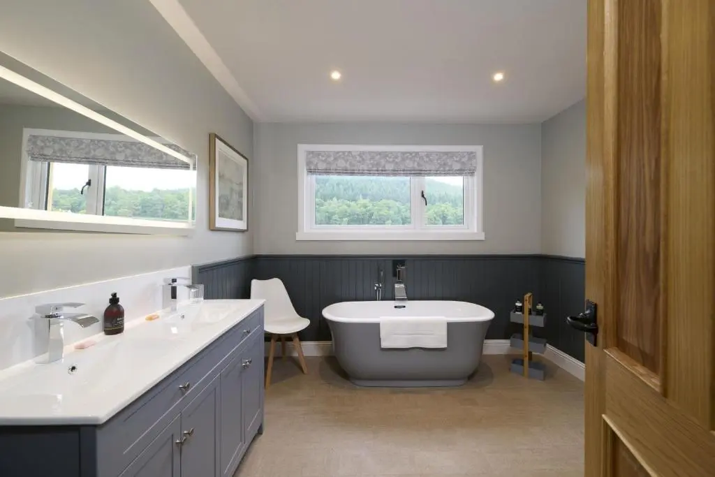a bathroom with two sinks and a bath tub at Upper Dunain in Inverness