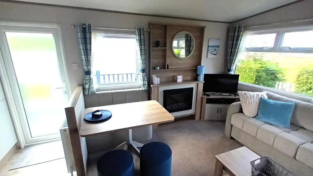 a living room with a couch and a table at Suki - up to 6 berth cabin, new. in Tain