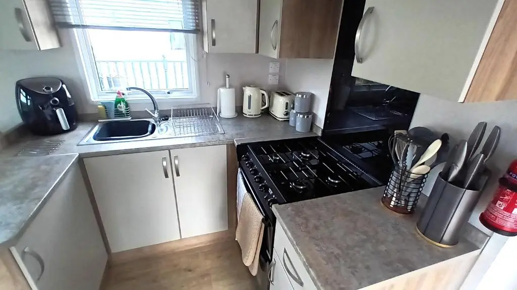 a small kitchen with a sink and a stove at Suki - up to 6 berth cabin, new. in Tain