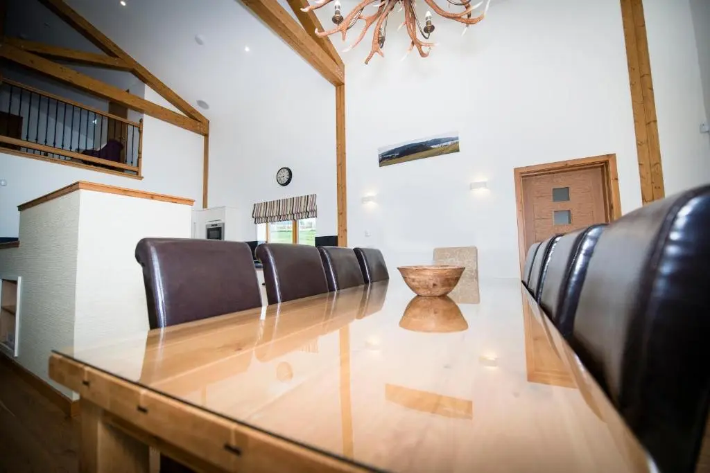 a dining room with a long table and leather chairs at Atlas in Nairn