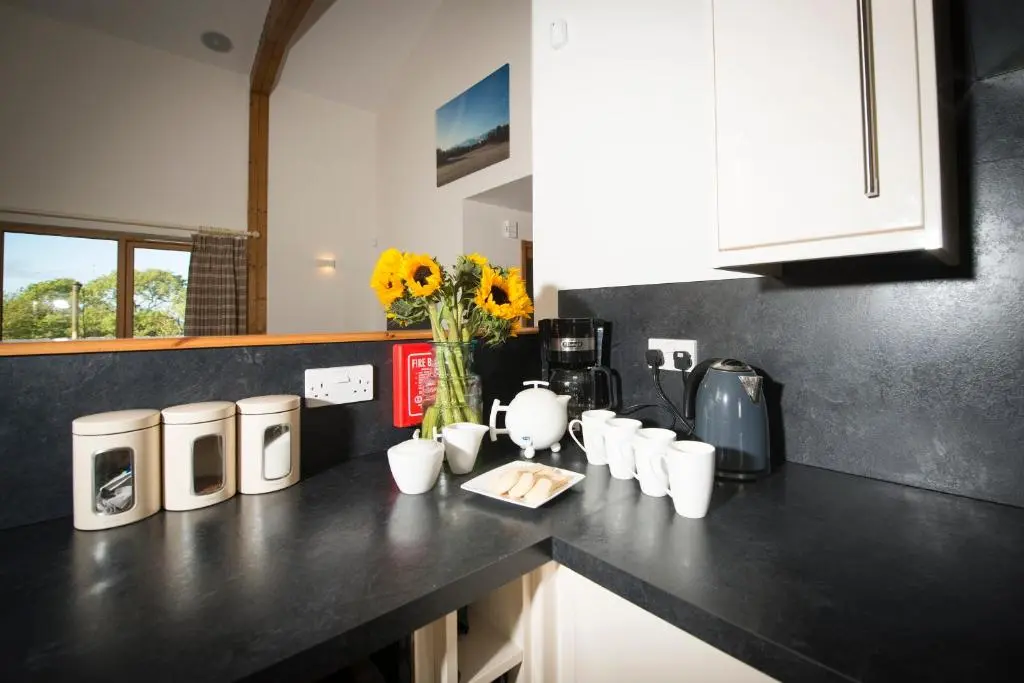 a kitchen with white appliances on a black counter at Aurae in Nairn