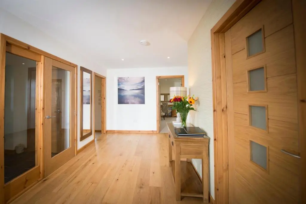 a hallway with a table with a vase of flowers on it at Aurae in Nairn