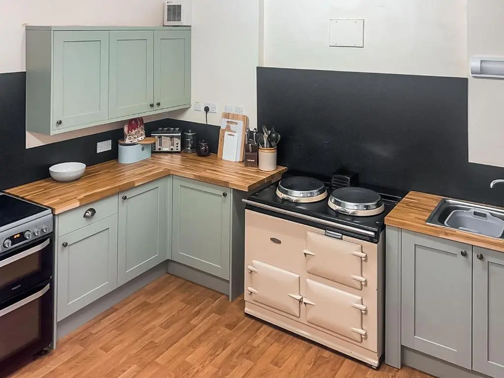 a kitchen with gray cabinets and a stove top oven at Gleneffock Farmhouse in Tarfside