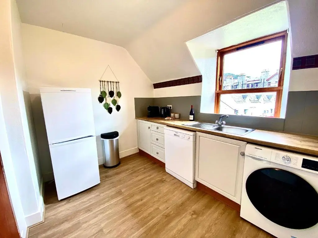 a kitchen with a white refrigerator and a sink at Bruachdryne Braemar Accommodation in Braemar