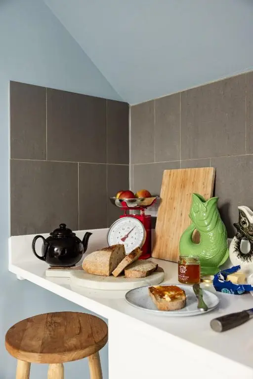 a kitchen counter with a plate of bread and a tea pot at The Hayloft in Banchory