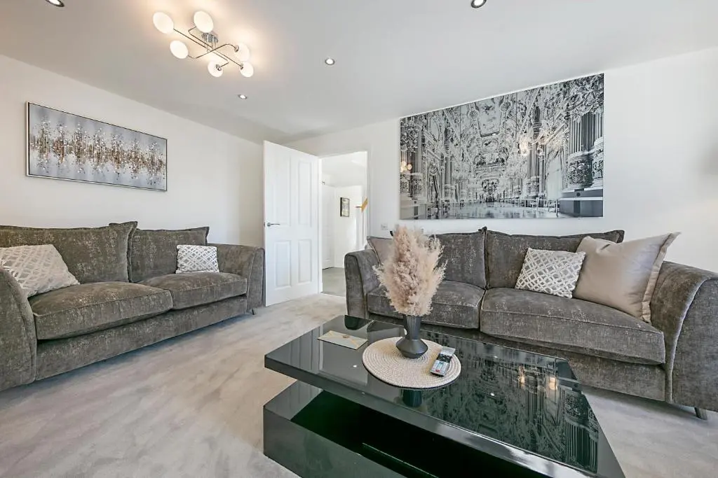 a living room with a couch and a table at Fern Place Villa - Grampian Lettings Ltd in West Cults