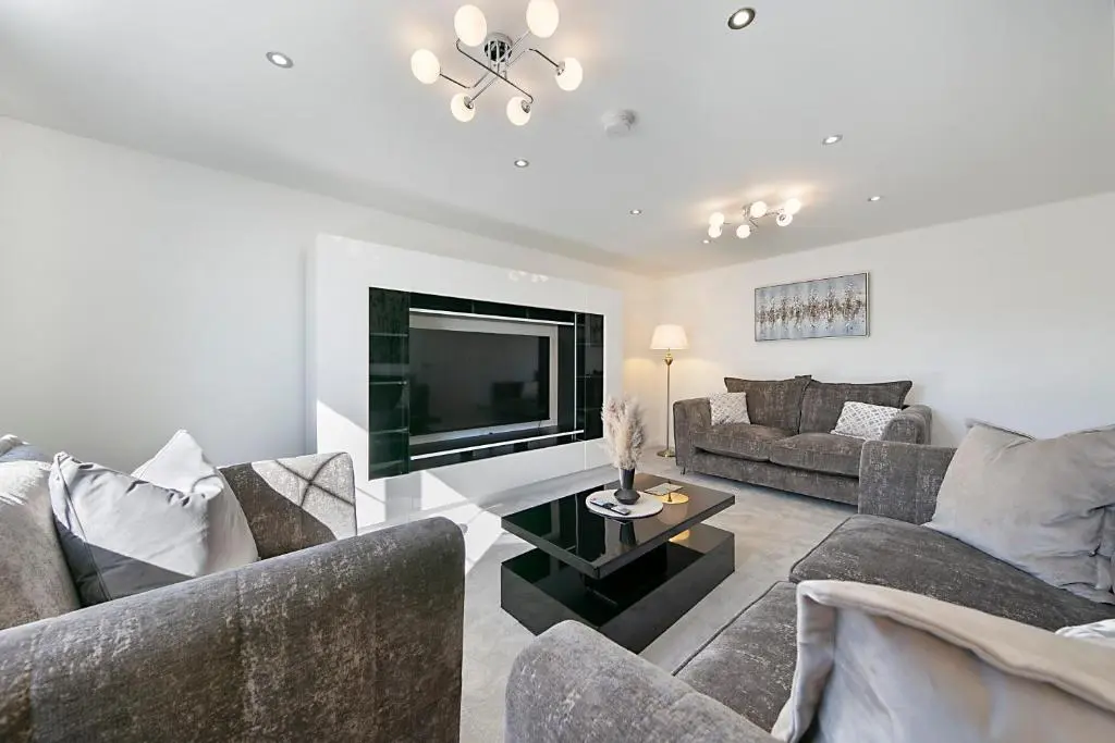 a living room with couches and a flat screen tv at Fern Place Villa - Grampian Lettings Ltd in West Cults