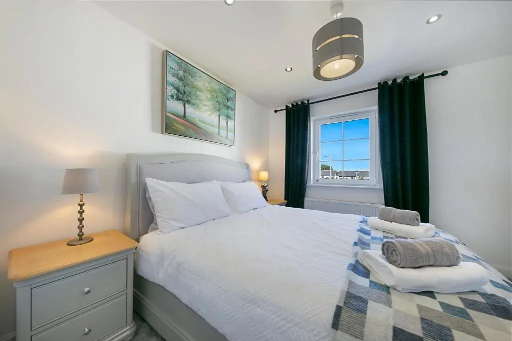 a bedroom with a white bed and a window at Fern Place Villa - Grampian Lettings Ltd in West Cults