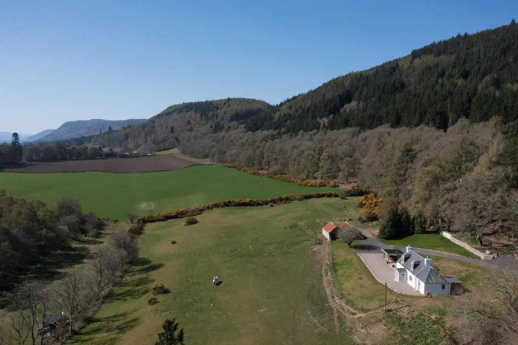 an aerial view of a house in the middle of a field at Balnacraig Farmhouse in Inverness