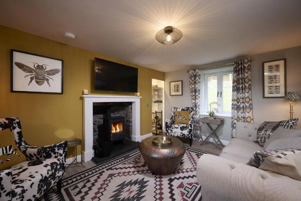 a living room with a couch and a fireplace at Balnacraig Farmhouse in Inverness