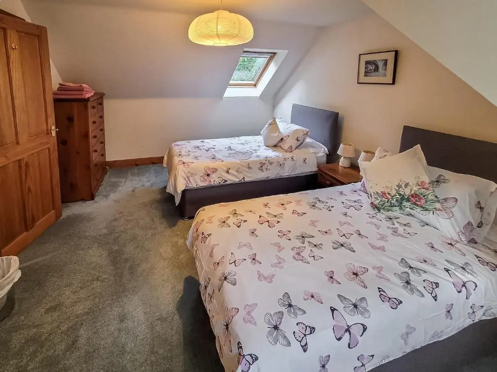 a bedroom with two beds and a window at South Lodge in Banchory