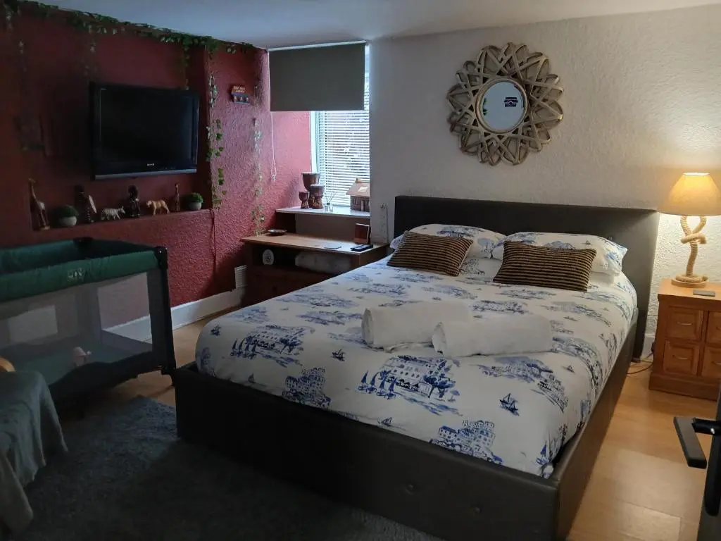a bedroom with a bed with blue and white sheets at The Hideaway Inverurie in Inverurie