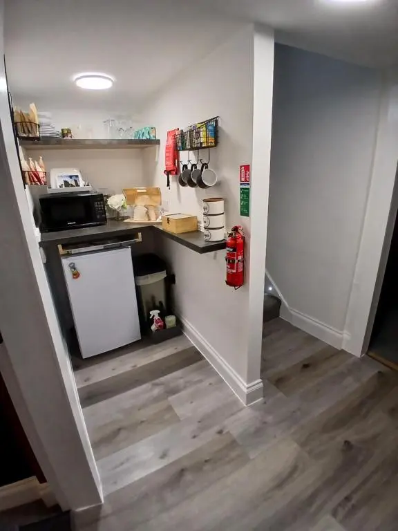 a small kitchen with a counter and a refrigerator at The Hideaway Inverurie in Inverurie
