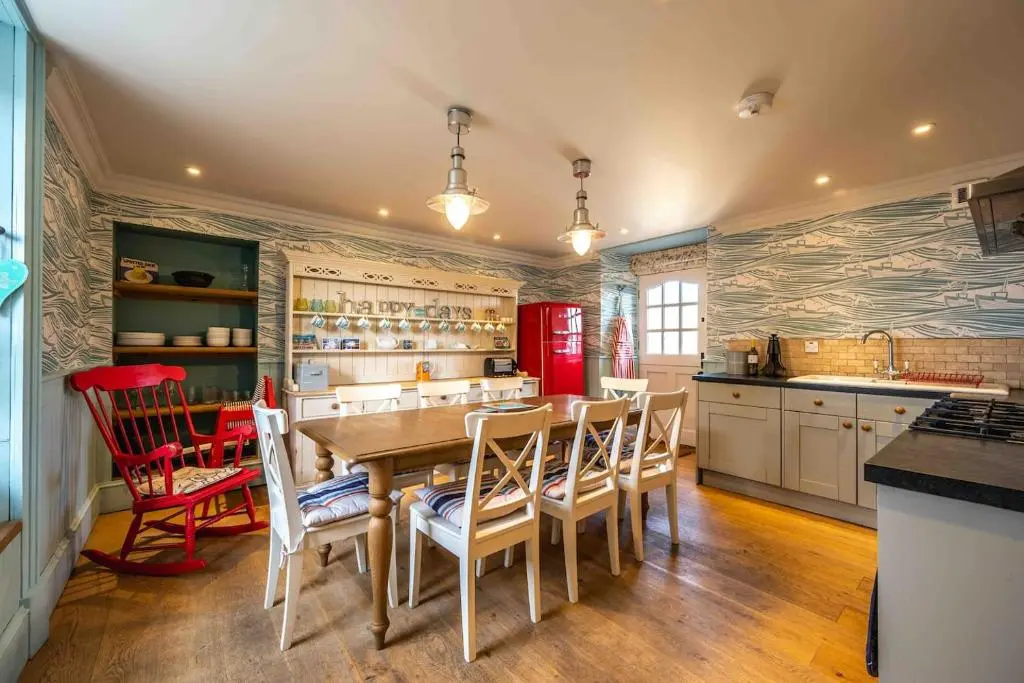 a kitchen with a table and chairs and a red refrigerator at The Millie Luxury Five Star with Sea View in Burghead