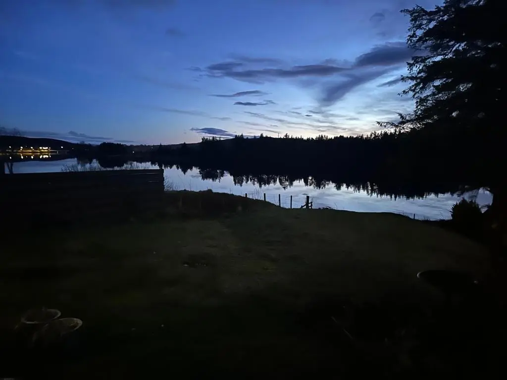 a view of a body of water at night at Lochside Lodge Pod in Lairg