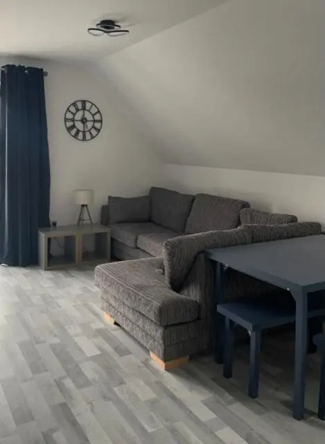 a living room with a couch and a table at Lochside Loft - Self Catering Apartment for 2 In a great location for Inverness Airport and both Cabot Highlands & Nairn Golf Courses in Inverness