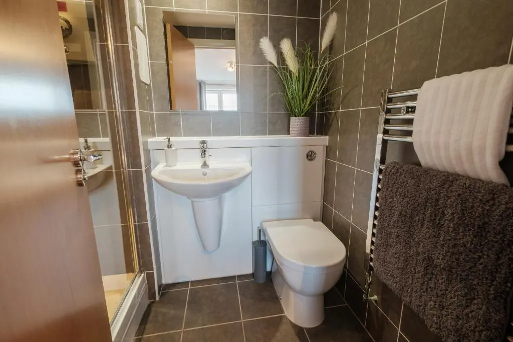 a bathroom with a toilet and a sink at Mackie Residence - SJA Stays - 3 Bed Apartment with parking in Westhill