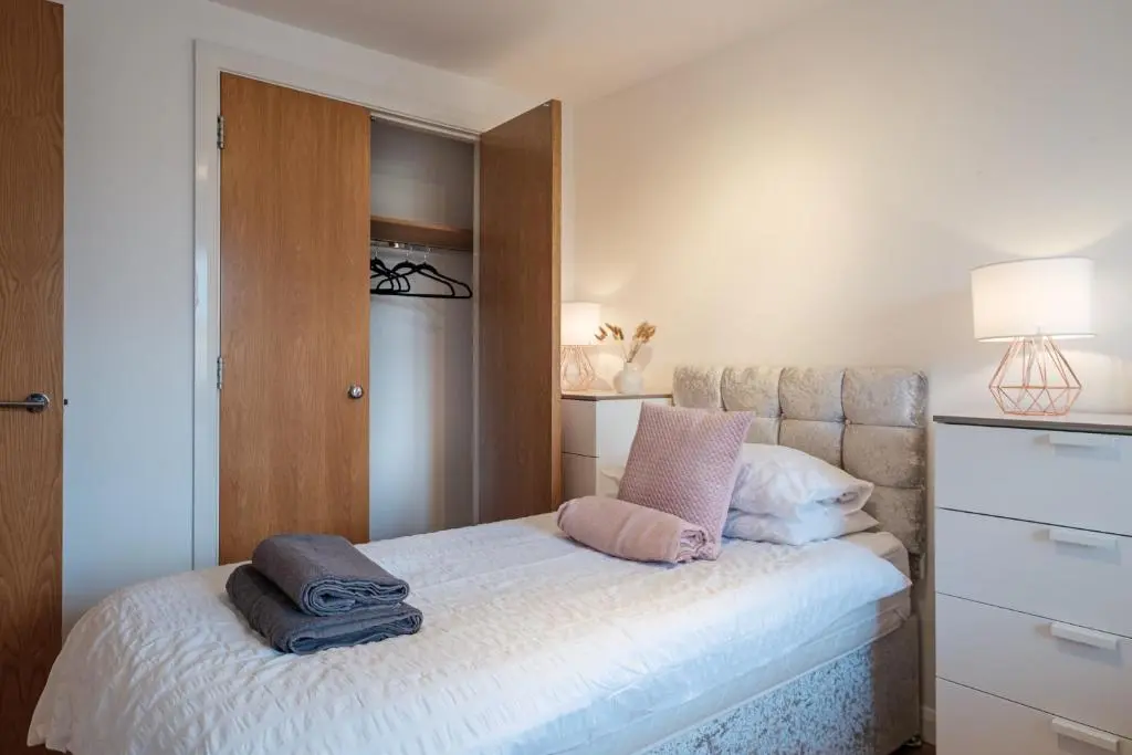 a bedroom with a bed with two pillows on it at Mackie Residence - SJA Stays - 3 Bed Apartment with parking in Westhill