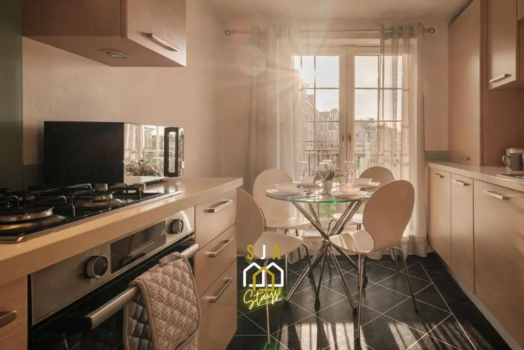a kitchen with a table and a stove top oven at Mackie Residence - SJA Stays - 3 Bed Apartment with parking in Westhill