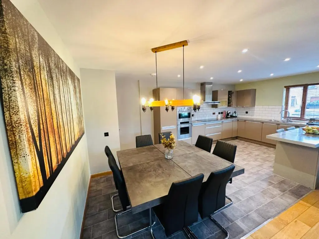 a kitchen and dining room with a table and chairs at 1 Woodside in Elgin