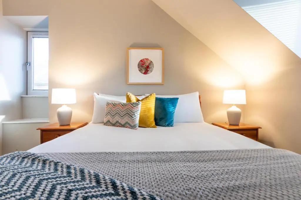 a bedroom with a large bed with two lamps at Sweet Ness River Flat in Inverness